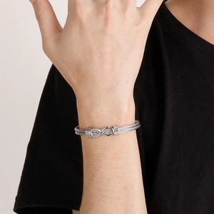 Detail of silver infinity symbol clasp on braided steel wire cable bracelet for men