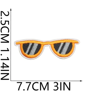 Detail view of orange sunglasses embroidered patch with dimensions 7.7cm x 2.5cm