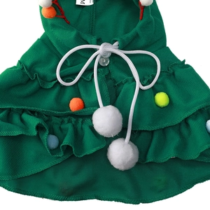 Detail of green waffle fabric dog Christmas cape with multicolor pom-poms in size M