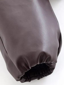 Détail du poignet d'une veste en cuir marron foncé avec un design élastique nervuré
