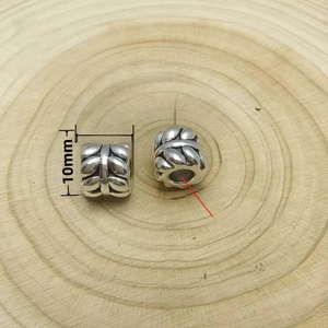 Detailed view of a silver cylinder bead with leaf texture, 10x8mm size for DIY jewelry