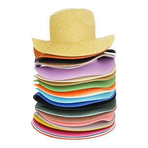 Dettaglio di cappelli di paglia intrecciati in vari colori vivaci e trama naturale
