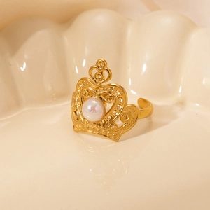 Macro shot of gold crown ring featuring a lustrous pearl inlay and hollow carvings
