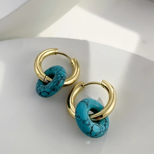 Detailed close-up of 18K gold-plated hoops with turquoise-patterned donut pendants