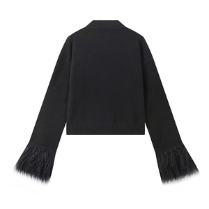 Detail von schwarzem Strickcardigan mit elegantem Federbesatz an den langen Ärmeln
