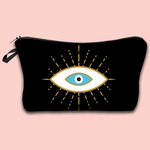 Detail of waterproof Evil Eye makeup bag with gold zipper on pink background