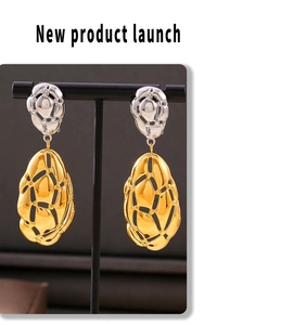Detail of hollow oval earrings with gold and silver color-blocking on a display