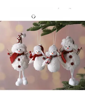 Set of four plush snowman Christmas ornaments with red scarves hanging on a pine tree