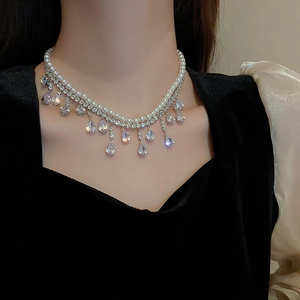 Dettaglio della collana a due strati con perle bianche e ciondoli in zircone a goccia