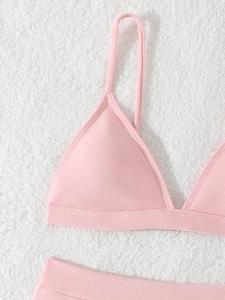 Pink ribbed triangle bikini top with adjustable thin straps on soft white faux fur