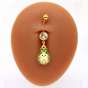 Dettaglio del piercing all'ombelico a coniglio dorato con goccia colorata e zircone
