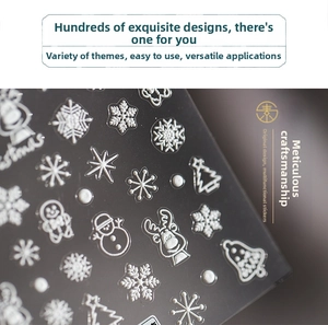 Macro shot of 5D embossed Christmas nail stickers with white snowflakes and reindeer