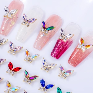 Macro detail of alloy butterfly nail charms with colorful rhinestones and gold base