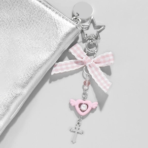 Pink bow keychain with silver star, heart wings and cross charms on a mini pouch