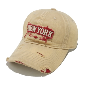 Detail of distressed brim and New York embroidery on khaki vintage baseball cap