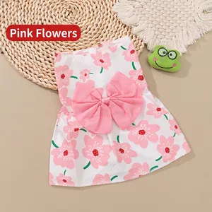 Detailed flat lay of a pet floral dress with a pink cherry blossom pattern and large bow
