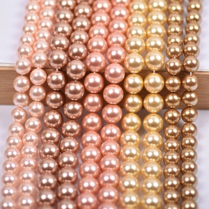 Macro detail of warm gradient glass pearl beads on wood display for necklace making