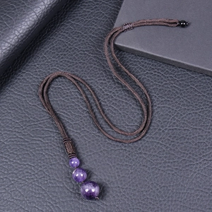Detail view of adjustable braided necklace with three gradient purple amethyst beads