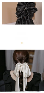 Detail of satin bow scrunchie with long ribbons in black and cream silk texture