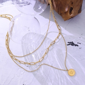 Layered gold titanium steel necklace with paperclip chain and round Carpe Diem pendant