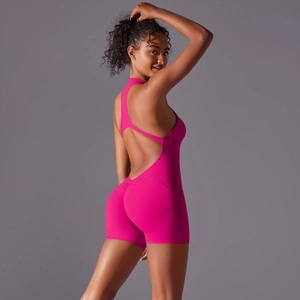 Macro detail of vibrant pink yoga bodysuit showing back seam stitching and peach lift