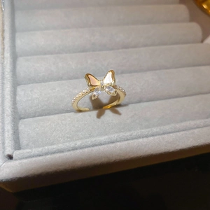 Detail view of gold butterfly ring with shell inlay and zircons in a jewelry box