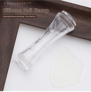 Close-up of double-headed silicone nail stamper with clear handle and scraper tool