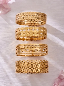 Close-up of four gold stainless steel bangles with hollow leaf and geometric patterns