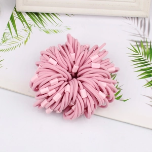 Detailed close-up of pink high-elasticity hair ties with matte plastic tube accents