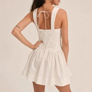 Elegante vestido corto blanco con escote cuadrado, espalda descubierta y talle de corsé