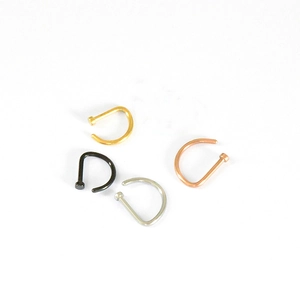 Close-up of D-shaped nose rings in gold, silver, rose gold, and black finishes