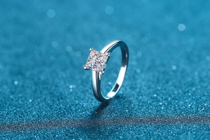 Macro shot of princess cut moissanite ring with four-prong setting and polished silver band