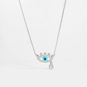 Macro detail of S925 sterling silver evil eye pendant with blue stones and teardrop crystal