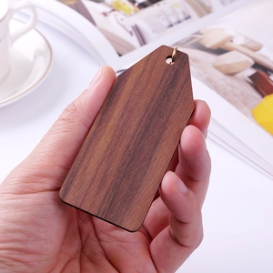 Handheld view of a walnut wood keychain with golden ring for custom hotel room engraving