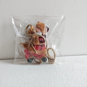 Detailed view of Santa Claus climbing rope ornament packaged in a clear protective polybag