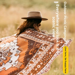 Detail of bohemian outdoor picnic blanket with cotton weave fringes and ethnic patterns