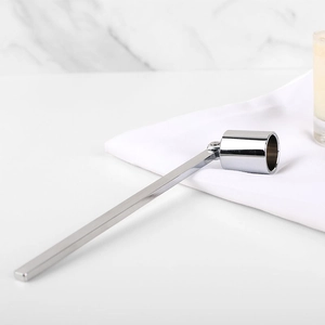 Polished silver stainless steel candle snuffer with long handle on marble background