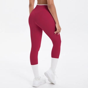 Détail du legging de yoga bordeaux à taille haute avec ceinture croisée contrastée blanche