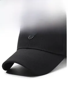 Detail of black baseball cap with structured brim and metallic shield emblem on textured fabric