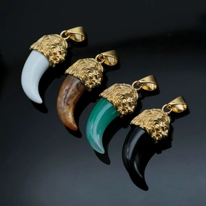 Four stainless steel lion head wolf tooth pendants in black, green, and marble resin