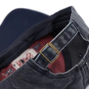 Detailed macro view of an adjustable metal buckle on a washed distressed baseball cap