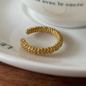Detailed view of 925 sterling silver gold ring with unique granular texture on ceramic