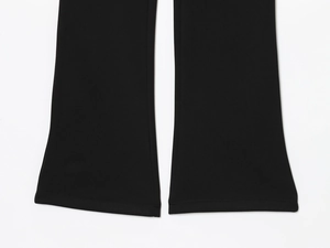 Detail view of black flare pants featuring reinforced double-needle stitching on the hem