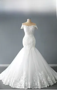 Broderies et paillettes détaillées sur l'ourlet d'une robe de mariée sirène blanche chic