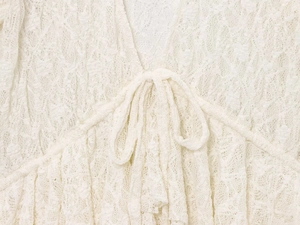 Gros plan sur la dentelle élégante et le nœud décoratif d'un chemisier blanc chic