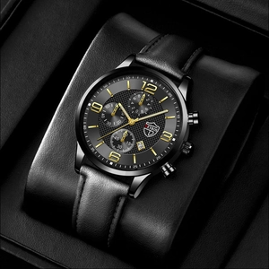 Détail d'une montre à quartz noire classique avec bracelet cuir et index dorés lumineux