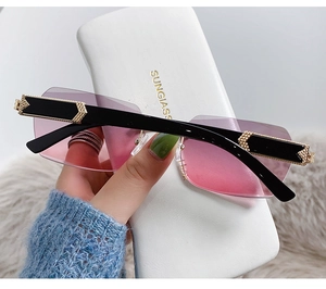 Detail of rimless pink gradient sunglasses with woven metal texture on temples