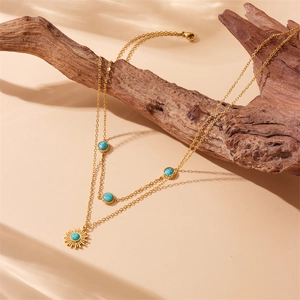 Double-layered gold sun pendant necklace with turquoise beads on vintage driftwood