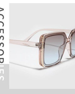 Macro shot of square pink sunglasses featuring blue gradient lenses and gold accents
