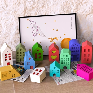 Colorful miniature house silicone molds and plaster ornaments on vintage newspaper